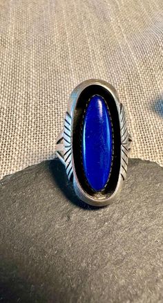 Sterling signed Navajo Ring with genuine oval elongate cabochon Lapis sawtooth bezel set, well balanced clean design.  Condition is very good for its age, pictures show the details.  Size 7 3/4, 1 1/8" north to south on finger, wt.- 11.2 grams.  The Lapis is gorgeous and set in a recessed oval frame with just the right amount of engraved detailing on the outer edges of the ring,  It is signed HS and beautifully finished giving it a timeless look. Classic Adjustable Oval Jewelry, Classic Handmade Oval Cabochon Jewelry, Handmade Classic Oval Cabochon Jewelry, Western Style Oval Gemstone Rings, Classic Collectible Rings With Oval Cabochon, Oval Gemstone Western Rings, Western Style Oval Rings For Gift, Adjustable Classic Jewelry With Oval Cabochon, Southwestern Style Oval Jewelry With Polished Finish