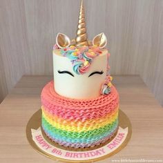 a rainbow cake with a unicorn face on top