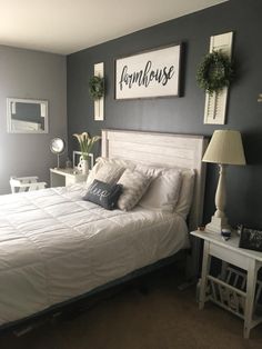 a white bed sitting in a bedroom on top of a wooden floor next to a lamp