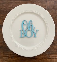 a plate with the word oh boy cut out on it, sitting on a wooden table