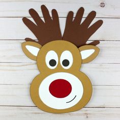 a paper reindeer mask with red nose and antlers on it's head, sitting on a white wooden surface