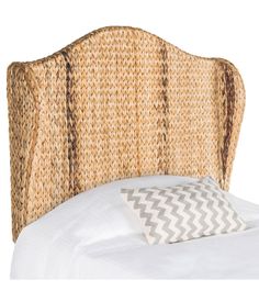 an upholstered headboard made out of woven material with white sheets and pillows