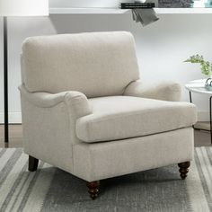 a white chair sitting on top of a rug in a living room