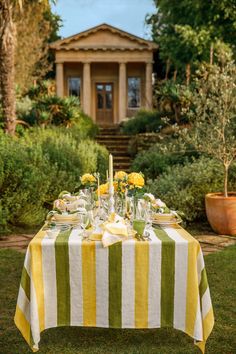 the table is set with yellow and green striped linens