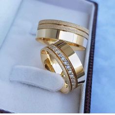 two gold wedding rings with diamonds in a box