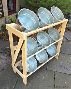 a rack filled with metal pans sitting on top of a sidewalk