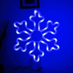 a lighted snowflake in the corner of a room with blue lighting on it