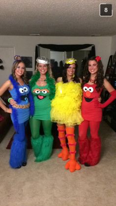 four women dressed up in costumes standing next to each other