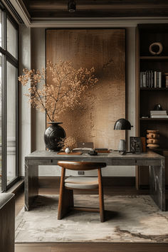 a table with a vase and some flowers on it in front of a large window