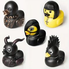 four rubber ducks with black hair and horns on their heads, all in different poses