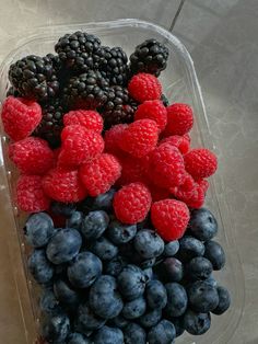 berries, raspberries and blueberries in a plastic container