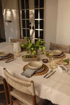 a table set with place settings for two people and plates on the dining room table