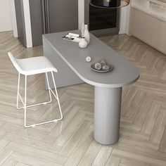 a white table and two stools in a room with wood flooring next to an oven