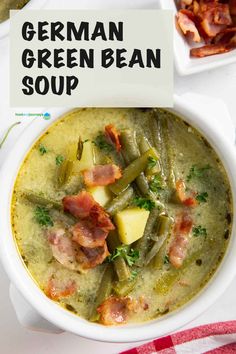 a white bowl filled with green bean soup and topped with bacon, potatoes and parsley