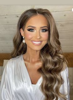 a beautiful woman with long hair wearing a white dress and smiling at the camera,