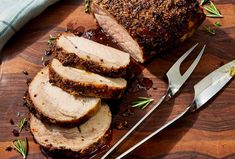 sliced pork on a cutting board with knife and fork