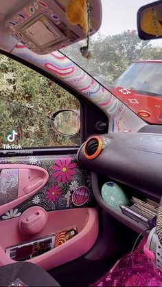 the interior of a car decorated in pink and black with flowers on the dash board