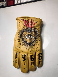 a pair of yellow leather gloves with an all seeing eye on the front and back