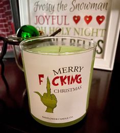 a green candle sitting on top of a wooden table next to a christmas tree ornament