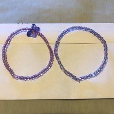 Pair of matching purple beaded bracelets, one light purple with a butterfly charm and the other light purple and purple Butterfly Bracelets, Purple Beaded Bracelets, Purple Beaded, Butterfly Bracelet, Purple Butterfly, Butterfly Charm, A Butterfly, One Light, Light Purple