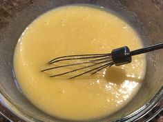 a whisk in a glass bowl filled with liquid