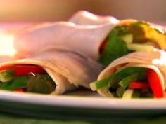 two wraps filled with veggies sit on a plate