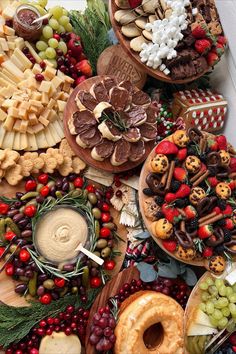 a table topped with lots of different types of food and desserts on top of each other