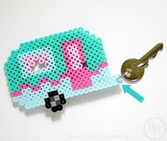 a cross stitch keychain with the word love spelled in pink and blue on it