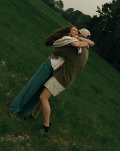 a man and woman hug in the middle of a field