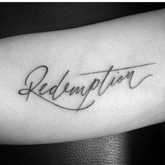 a black and white photo of a tattoo with the word redention in cursive writing