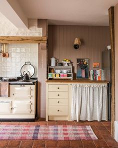 a kitchen with an oven, stove and rug on the floor in front of it