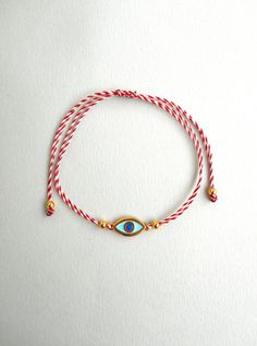 Martis bracelet, Evil eye bracelet Gold enamel charm, Waxed cord March bracelets, Red and White, Twisted string, Greek Tradition Unisex gift The March bracelet is an ancient Greek custom. From the beginning of March, people wear a bracelet made of white and red twisted thread. According to the tradition, the March bracelet protects those from burning of the first sun of spring. The last day of March,the bracelet is left on trees so that swallows can use it for building their nests. Bracelet is m Gold Braided Evil Eye Bracelet As A Gift, Gold Braided Bracelet With Evil Eye As Gift, Gold Braided Bracelet With Evil Eye For Gift, Gold Evil Eye Bracelet With Sliding Knot As Gift, Red Waxed Cord Friendship Bracelets, White Nylon Cord Friendship Bracelets As Gift, White Waxed Cord Friendship Jewelry, Gold Waxed Cord Friendship Bracelets As Gift, Red Adjustable Friendship Jewelry