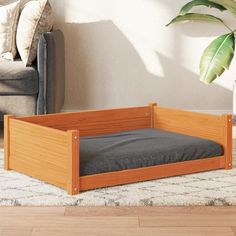 a wooden dog bed sitting on top of a rug