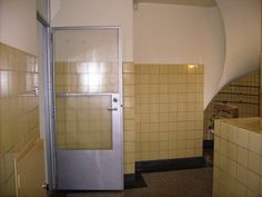 a bathroom with yellow and white tiles on the walls