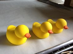 three yellow rubber ducks sitting on top of a counter