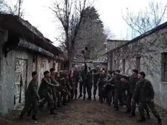 a group of men standing around each other in front of an old building with graffiti on it