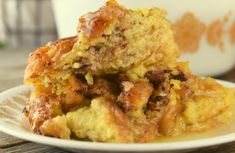 a close up of a plate of food on a table with a cup in the background