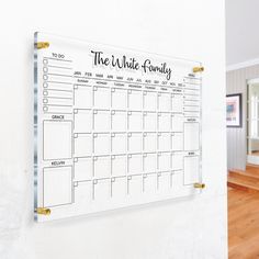 a white board mounted to the side of a wall next to a wooden floor and door