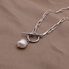 D E T A I L S  * Silver plated paperclip chain and toggle clasp * Chain: 4x10 links * Freshwater pearl pendant C A R E  Plated jewelry will tarnish if not properly cared for! Please follow the below tips to extend the life of your jewelry  * Allow lotions and perfumes to soak in prior to wearing * Remove before showering, swimming, and exercising  * Store in a closed bag or box when not wearing * Avoid chemical contact (acetone, aerosols, chlorine, etc) S H I P P I N G  Free domestic shipping! P Silver Toggle Necklace With Pearl Charm Gift, Paperclip Necklace With Toggle Clasp As A Gift, Gift Pearl Chain Toggle Necklace, Silver Toggle Necklace With Pearl Chain As Gift, Paperclip Necklace With Toggle Clasp For Gift, Metal Toggle Necklace With Paperclip Chain, Silver Toggle Necklace With Paperclip Chain, Sterling Silver Necklace With Adjustable Paperclip Chain, Dainty Pearl Necklace