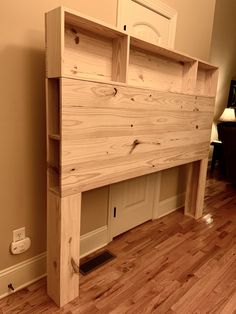 a wooden bed frame sitting on top of a hard wood floor next to a wall