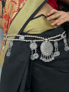 Oxidized silver kamarpatta waistbelt waist chain for women. The look is stunning and preciously suitable for all kinds of dressy occasions. The kamarband for women wedding is an amazing ethnic jewelry collection is ideal for wedding and also for all other traditional, casual and regular occasions that will add class and style to your look. A perfect gift for your daughter, mother, sister, friend, fiancée or bride. Silver-plated Light weight waist belt for your comfort. Trendy & Latest fashion. A Silver Bohemian Body Chain For Festivals, Bohemian Silver Body Chain For Wedding, Bohemian Silver Waist Chain As Gift, Bohemian Silver Body Chain As Gift, Silver Bohemian Waist Chain For Festivals, Bohemian Silver Waist Chain For Festivals, Elegant Silver Chain Belt For Festival, Traditional Waist Chain With Latkans For Festivals, Silver Bohemian Chain Belt For Festivals