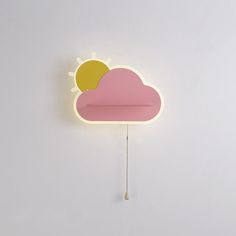 a clock with a cloud and sun on the face, hanging from a chain in front of a white wall