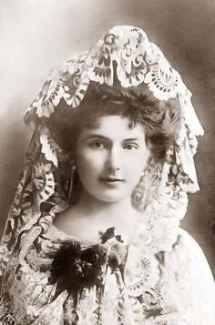 an old black and white photo of a woman wearing a bonnet with flowers on it