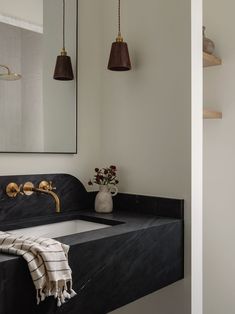 a bathroom sink sitting under a large mirror next to a wall mounted faucet