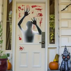 a door decorated with halloween decorations and an image of a woman holding her hand up