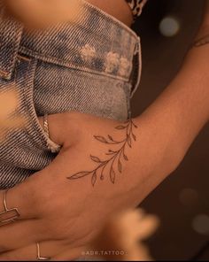 a close up of a person's arm with a flower tattoo on the wrist