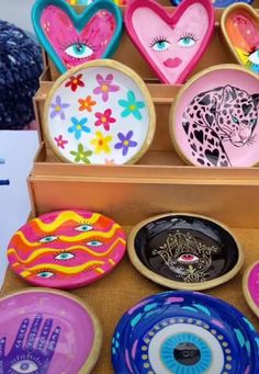 there are many colorful plates on display in the box, including one with an eye