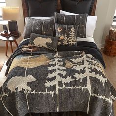 a bed covered in a black and white comforter with bear designs on the cover