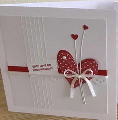 a white card with red and white hearts on it