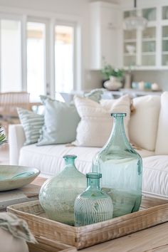 some vases are sitting on a tray in the middle of a living room table